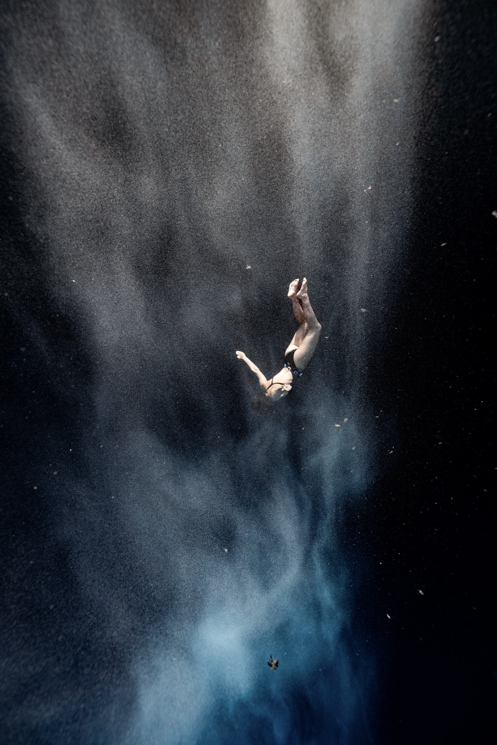 Natalie Bruce freefalling through a cloud of particles in the deep at Dean's Blue Hole