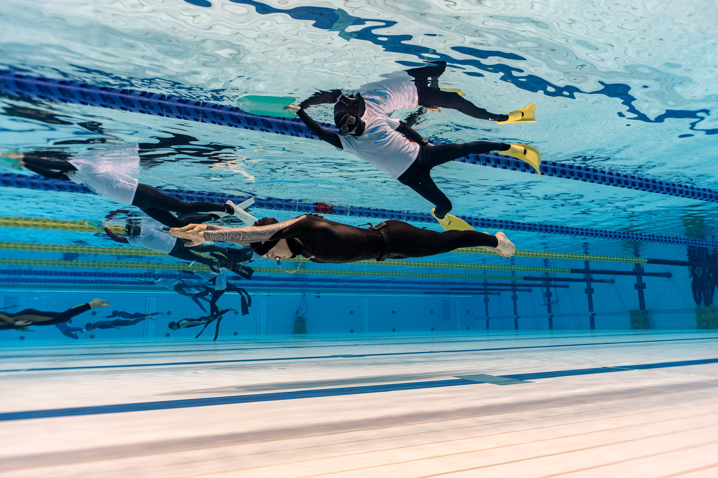 Natalie Bruce and training partners doing dynamic apnea in the pool