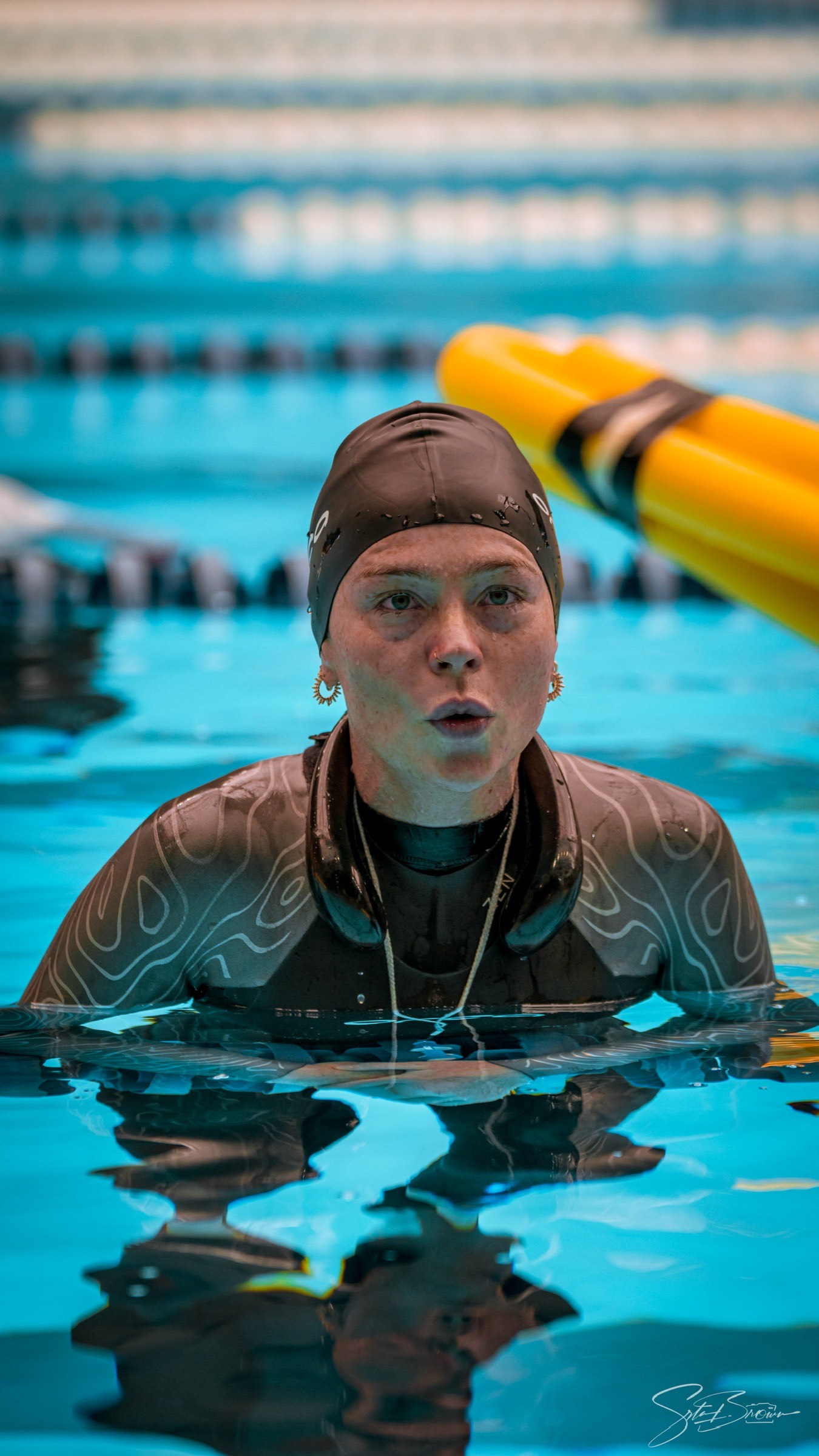 Natalie Bruce at the surface in the pool wearing a training cap